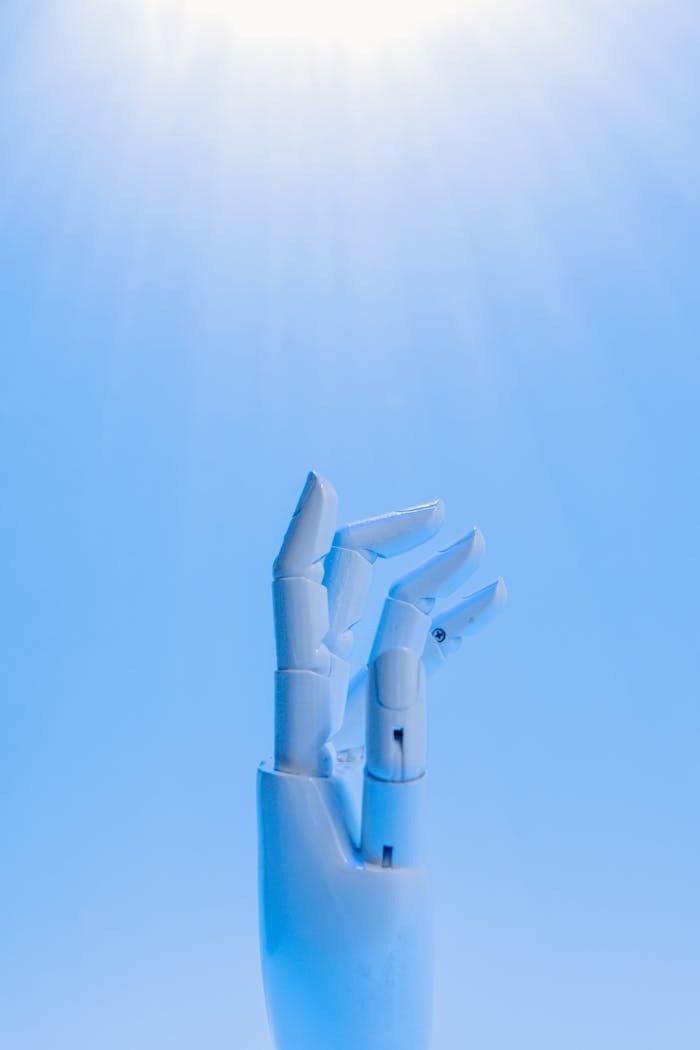 A robotic hand reaching upward against a blue sky, symbolizing technologys future.